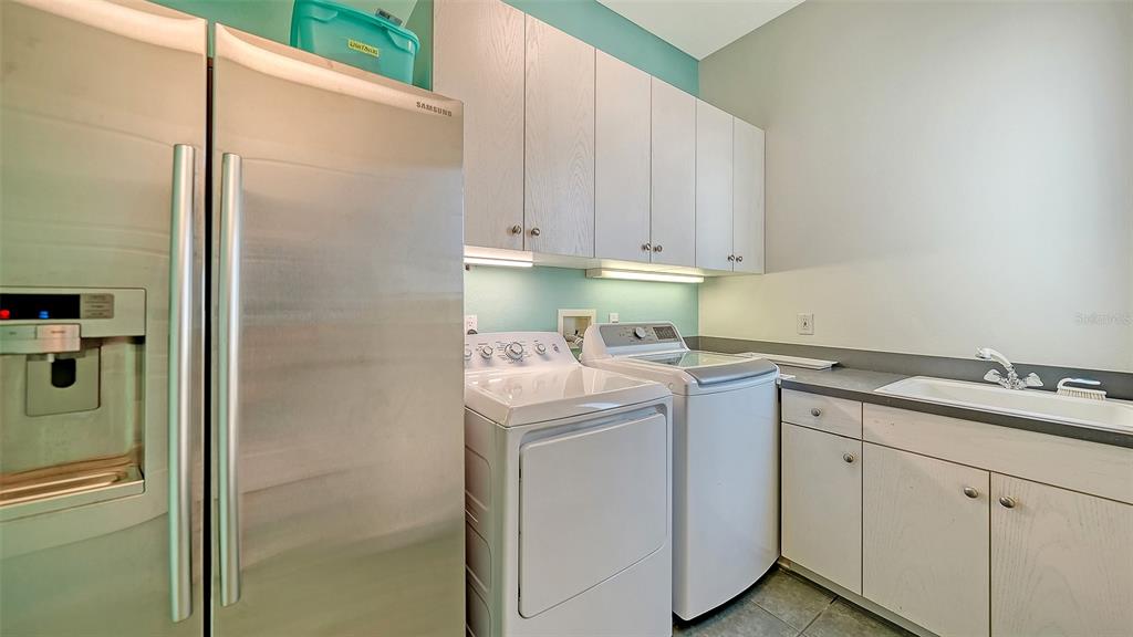 6477 Gulfside Road Longboat Key, FL 34228 - Photo 49 of 65 a utility room with cabinets washer and dryer