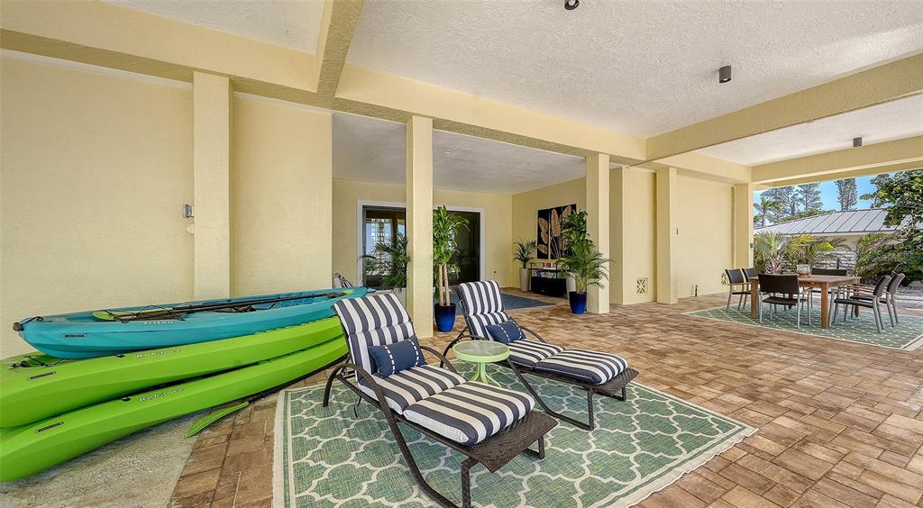 6477 Gulfside Road Longboat Key, FL 34228 - Photo 54 of 65 a living room with furniture and a dining table with floor to ceiling window