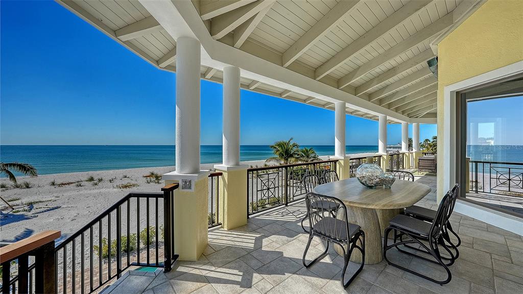 6477 Gulfside Road Longboat Key, FL 34228 - Photo 58 of 65 a view of a patio with table and chairs with wooden floor and fence