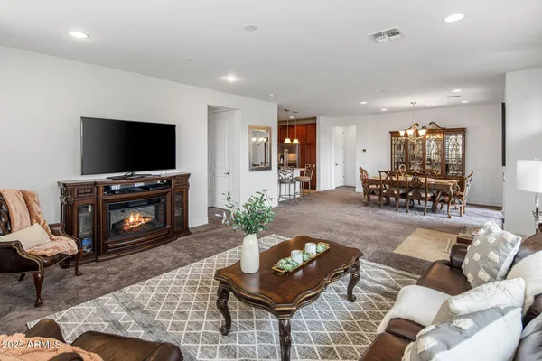 a living room with furniture a flat screen tv and a fireplace