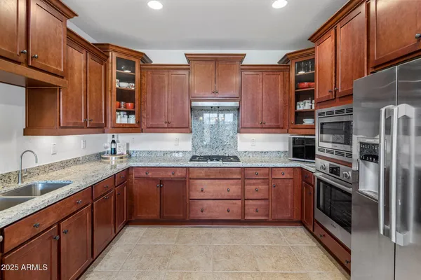 a kitchen with stainless steel appliances granite countertop wooden cabinets a sink and dishwasher