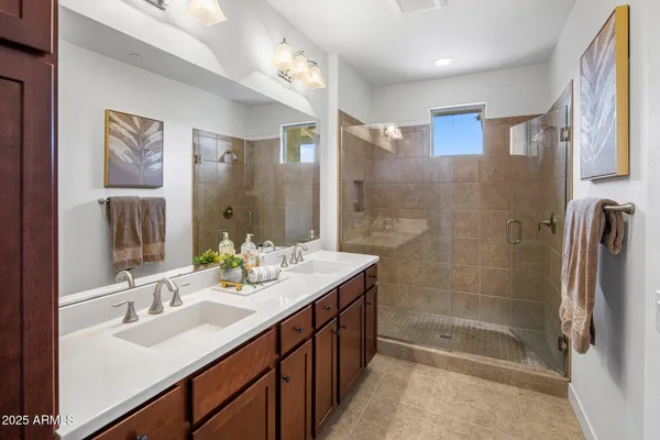 a bathroom with a double vanity sink mirror and shower