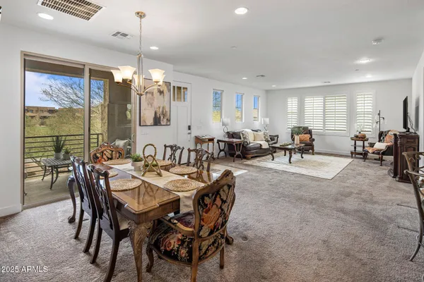 a dining room with furniture a chandelier and window