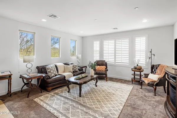 a living room with furniture two window and a table