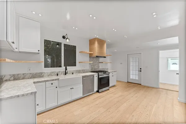 a kitchen with a sink stainless steel appliances and white cabinets