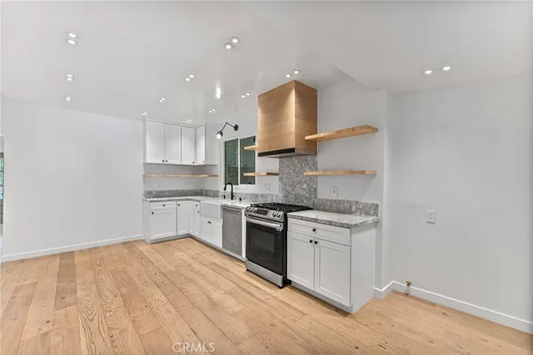 a kitchen with a stove sink and cabinets