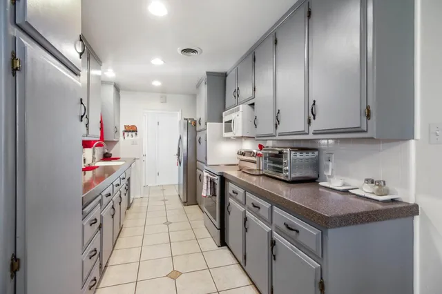 a kitchen with granite countertop lots of counter top space and stainless steel appliances