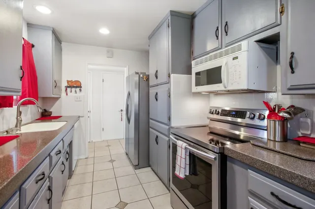 a kitchen with stainless steel appliances granite countertop a stove a sink and a refrigerator