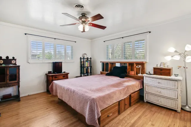 a spacious bedroom with a bed and a flat screen television