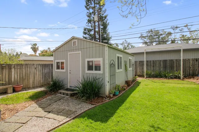 a front view of a house with a yard and fountain in middle