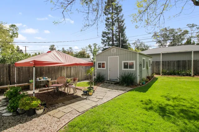 a view of a house with backyard sitting area and garden