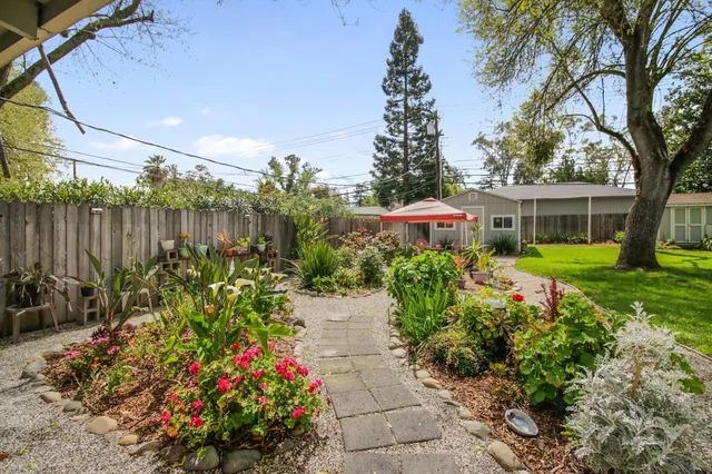 a view of a chair and table in backyard of the house