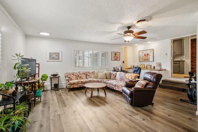 a living room with furniture and a wooden floor