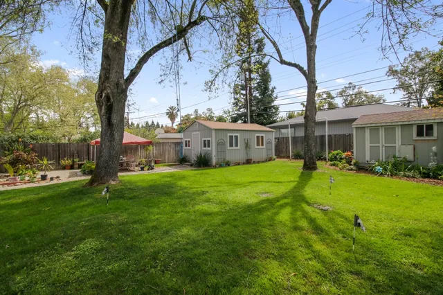 a view of a house with backyard and a tree