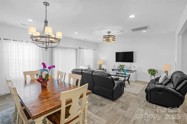 a living room with furniture a chandelier and a flat screen tv