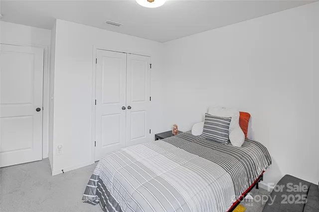 a bedroom with a bed and a night stand