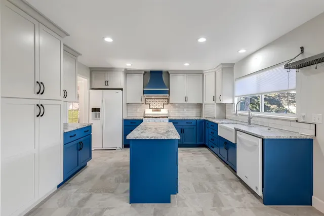 a kitchen with stainless steel appliances granite countertop a refrigerator sink and stove