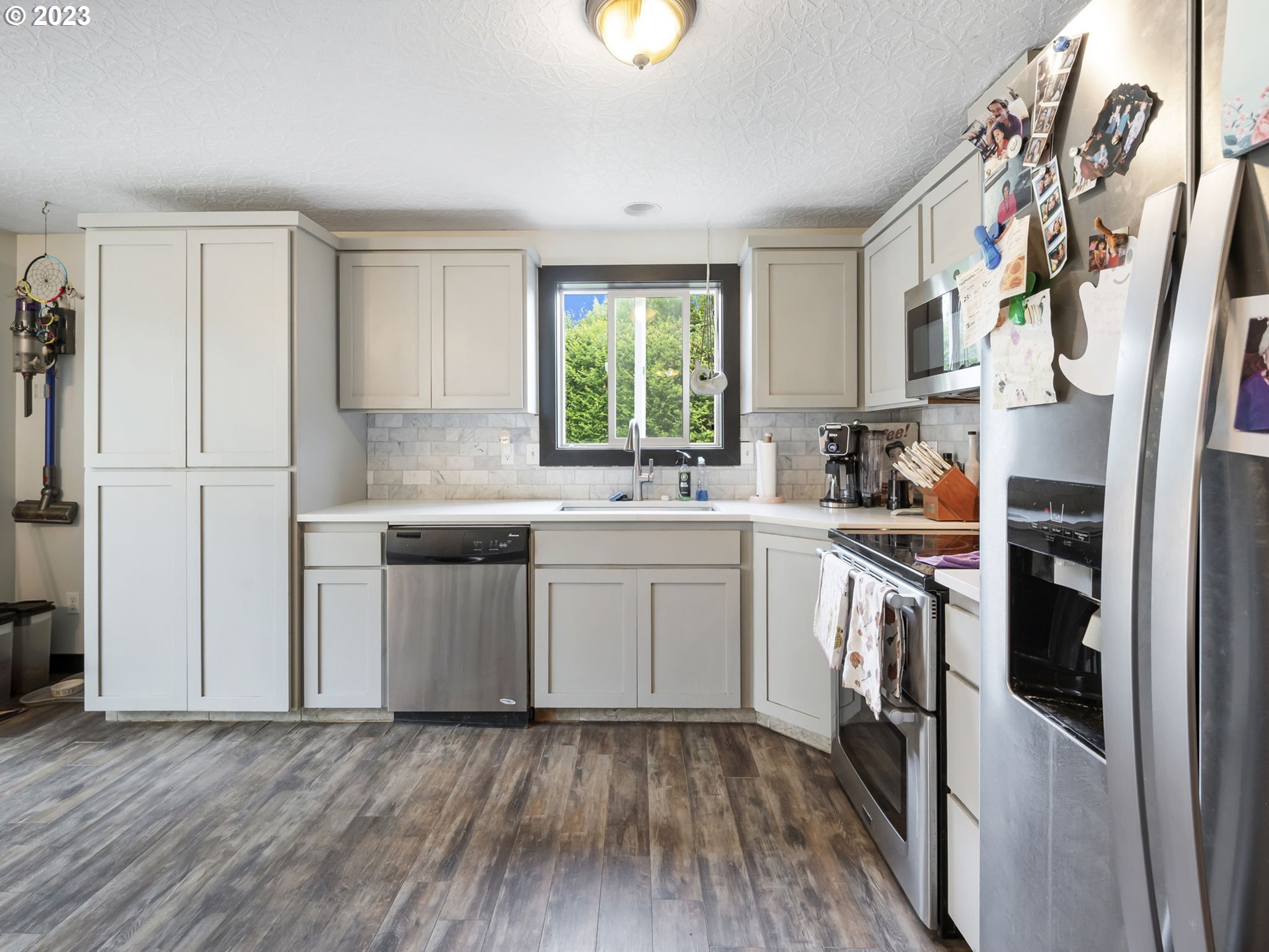 4413 Addy Loop Washougal, WA 98671 - Photo 6 of 28 a kitchen with a sink cabinets stainless steel appliances and a window