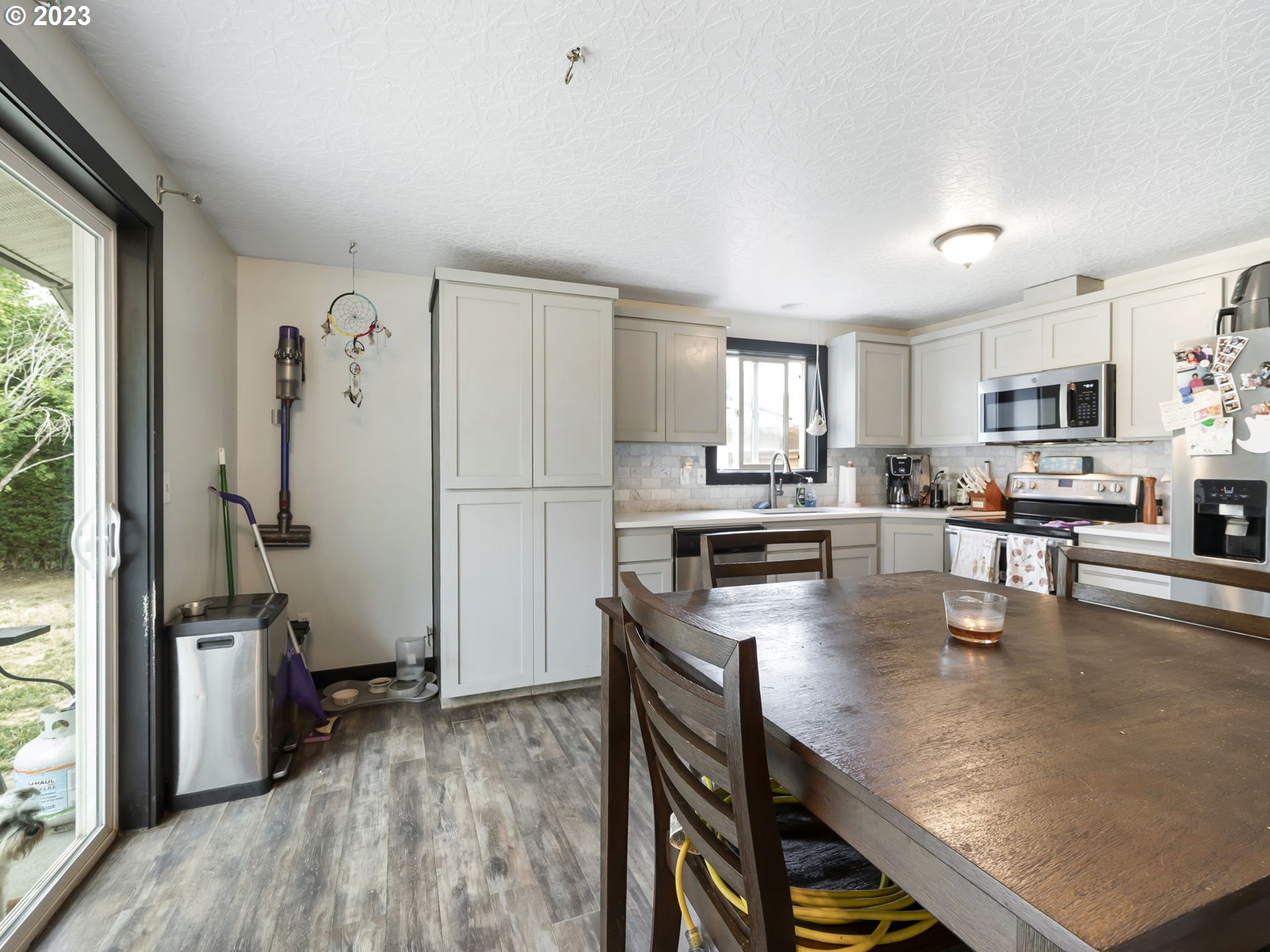 4413 Addy Loop Washougal, WA 98671 - Photo 10 of 28 a kitchen with stainless steel appliances granite countertop a refrigerator a stove top oven a sink dishwasher and white cabinets with wooden floor