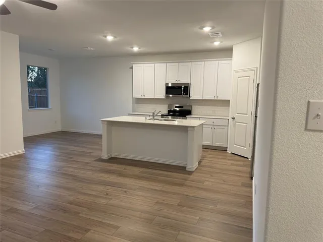 a kitchen with stainless steel appliances a sink a stove a refrigerator and cabinets
