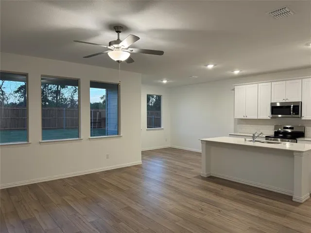 a view of a kitchen with a sink cabinet window and wooden floor
