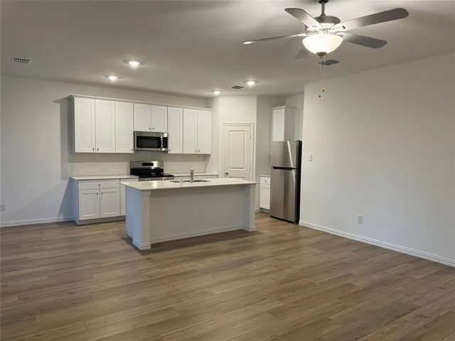 a large kitchen with stainless steel appliances granite countertop a stove a sink and a refrigerator