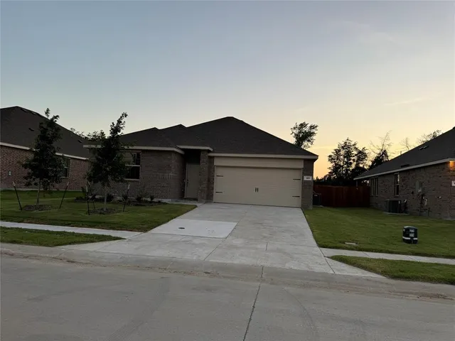 a front view of a house with a yard and a garage