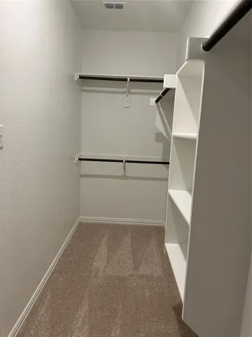 a view of walk in closet with empty racks