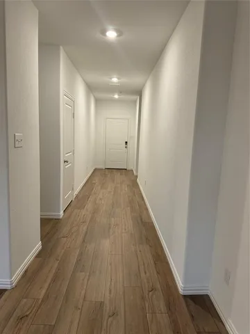 a view of a hallway with wooden floor