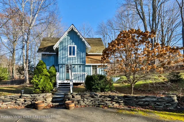 a front view of a house with a tree