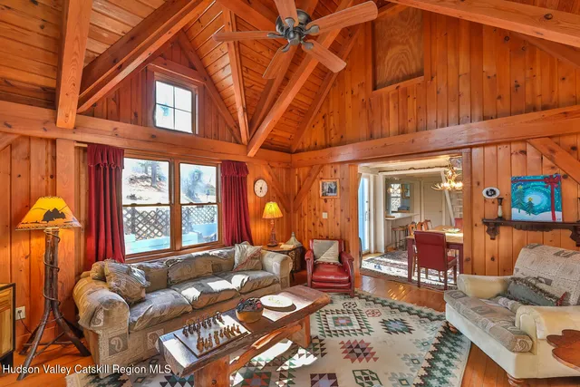 a living room with furniture a couch and dresser with wooden floor