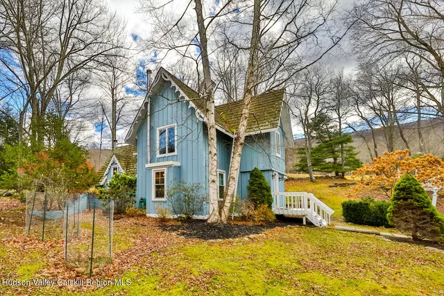 a front view of house with yard and trees around