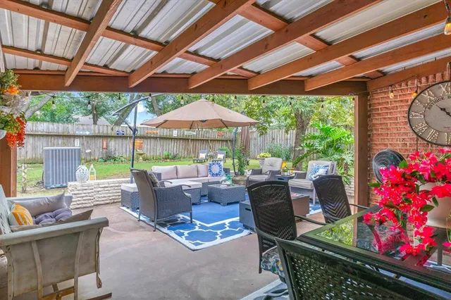 a view of a patio with table and chairs under an umbrella