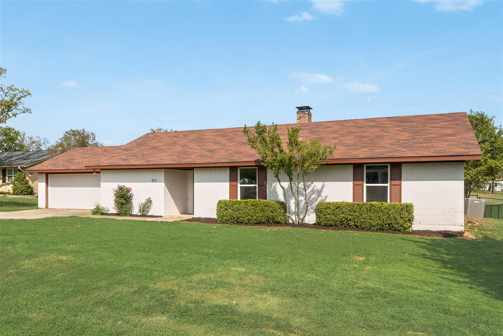 407 Cocopa Drive West Gainesville, TX 76240 - Photo 1 of 1 a front view of a house with a yard and garage