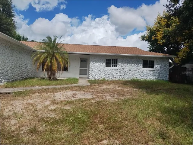 a front view of house with yard and trees around