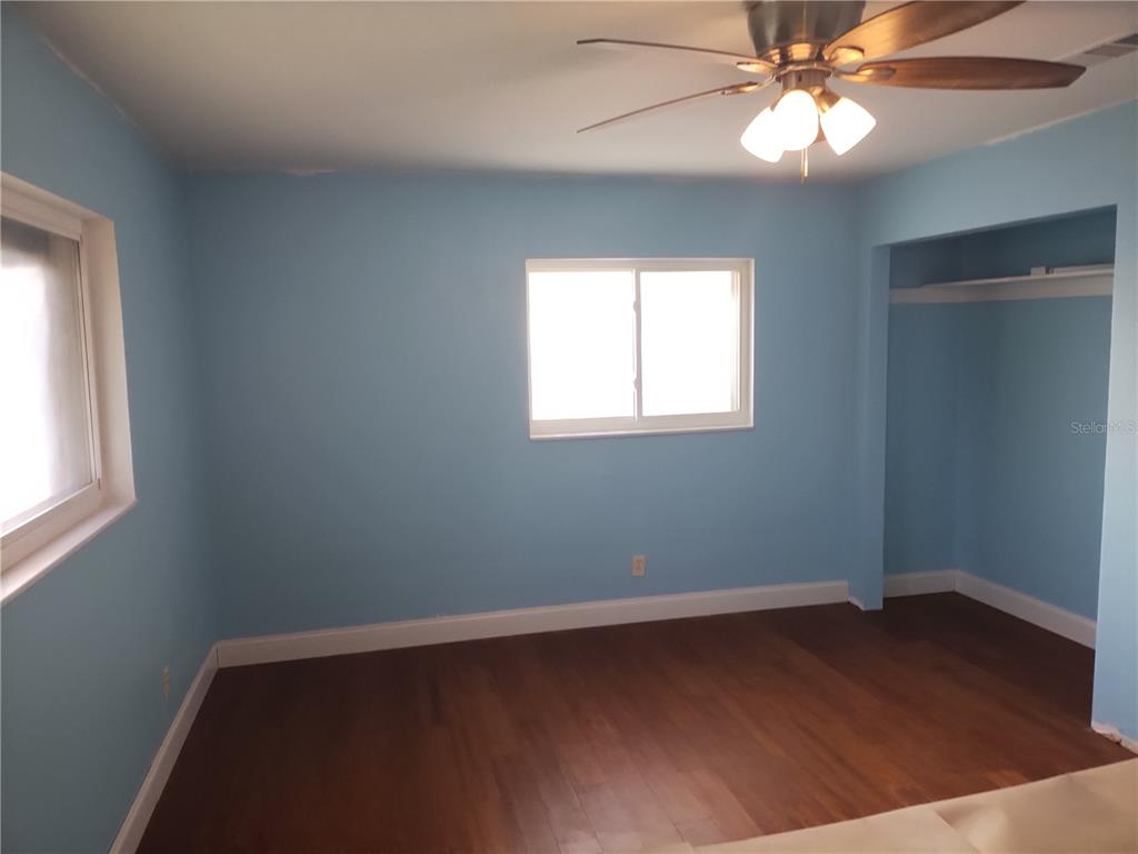 3822 Ravenna Drive Valrico, FL 33594 - Photo 2 of 2 an empty room with wooden floor fan and windows