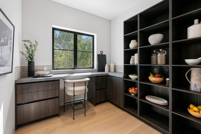 a kitchen with a refrigerator and white cabinets