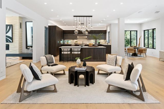 a living room with furniture white walls and kitchen view