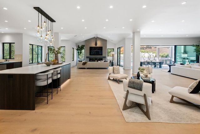a living room with furniture a flat screen tv and a large window