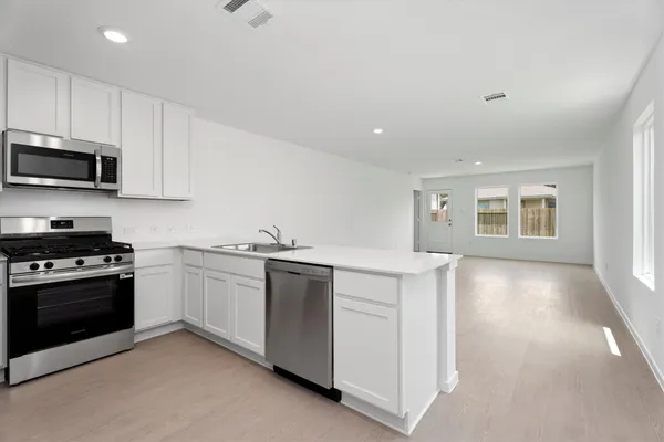 a kitchen with stainless steel appliances granite countertop a stove and a sink