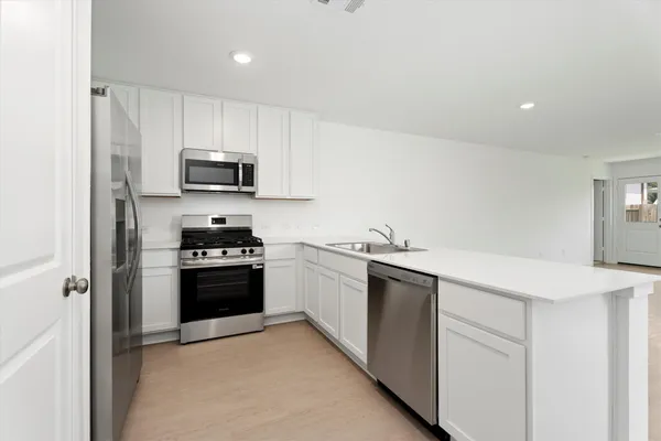 a kitchen with stainless steel appliances a sink stove and refrigerator