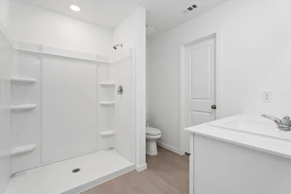 a bathroom with a sink a toilet and shower
