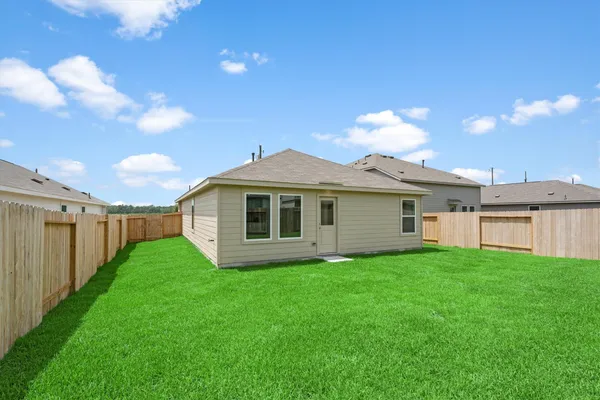 a view of a house with a yard and potted plants