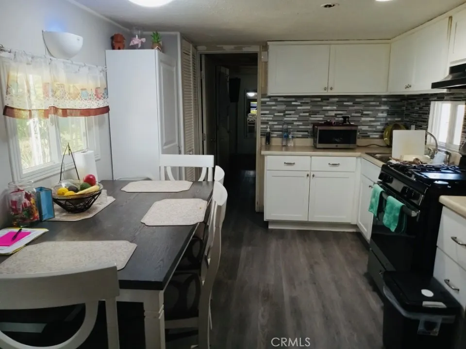 26235 East 9th, Unit 36 Highland, CA 92346 - Photo 1 of 15 a kitchen with a table chairs a stove and a refrigerator