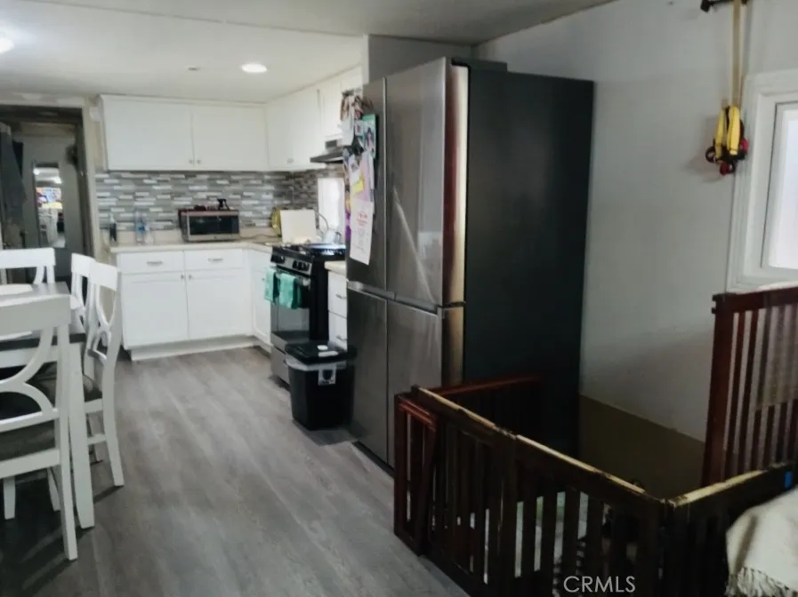 26235 East 9th, Unit 36 Highland, CA 92346 - Photo 4 of 15 a kitchen with a refrigerator and white cabinets