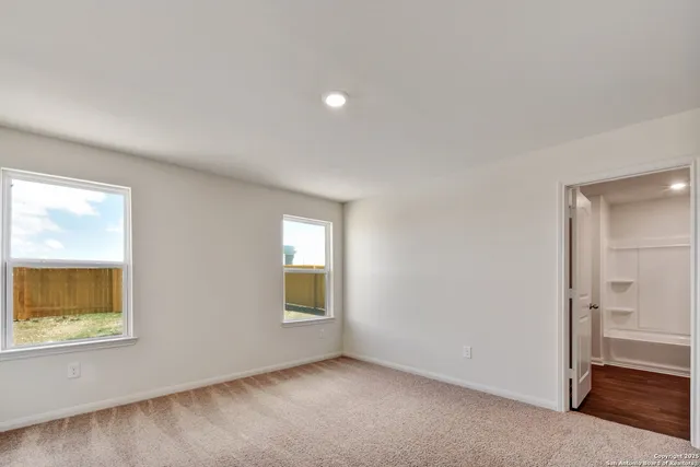 an empty room with a window and wooden floor