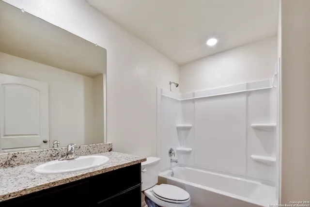 a bathroom with a granite countertop sink toilet a mirror and shower