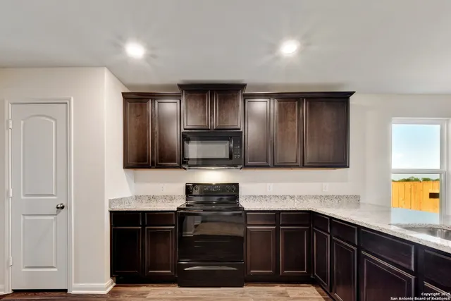 a kitchen with granite countertop a stove and cabinets
