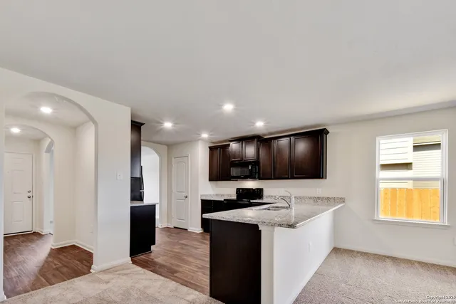 a view of kitchen with stainless steel appliances kitchen island sink stove and refrigerator