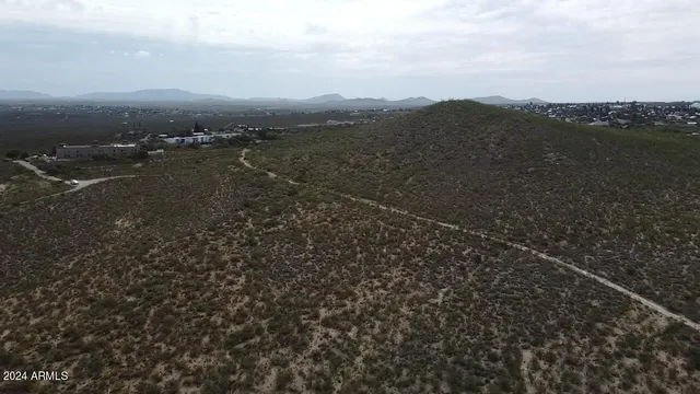 a view of a dry yard with wooden fence